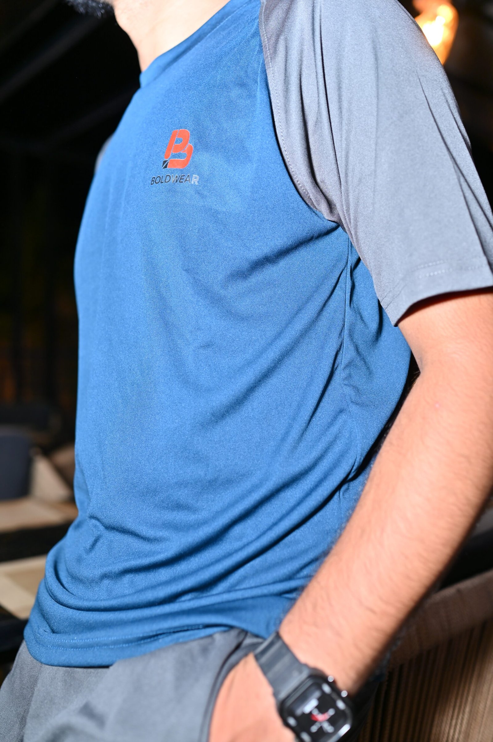 Men wearing a premium blue performance T-shirt with grey track pants for gym and casual wear.